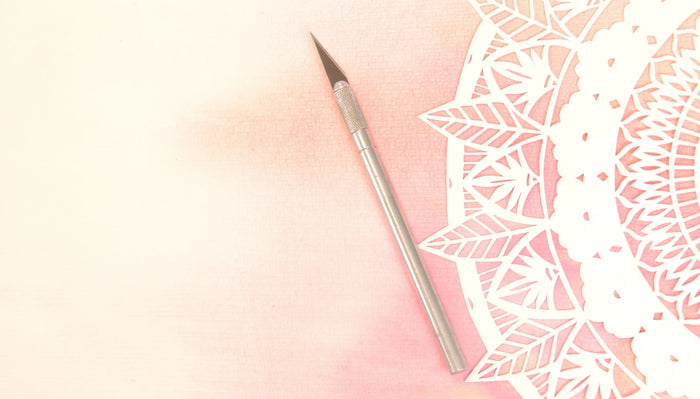 Vu du dessus, un scalpe et une feuille de papier découpée